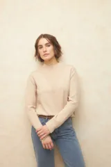 Polera negra de jacquard con cuello alto y aberturas en los laterales y en las mangas.