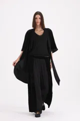 Spolverino largo de terciopelo negro, con mangas tres cuartos y lazo ajustable en la cintura.