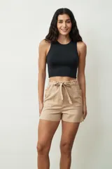 Short de gabardina color beige con cintura elástica alta, detalle de lazo ajustable y bolsillos frontales amplios.