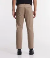 Pantalón de corte slim y estilo cropped, confeccionado en tejido plano de algodón con un toque de elastano. Presenta cierre frontal con botón y cremallera, trabillas para cinturón y bolsillos laterales y traseros.