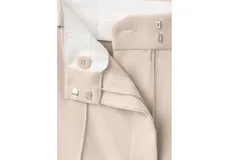 Pantalón de vestir de tiro medio, color beige, de corte recto y amplio con pinzas frontales.
