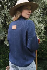 Campera tejida de punto con textura de rayas verticales, cierre frontal completo y cuello alto. Diseño de manga larga con hombros caídos.