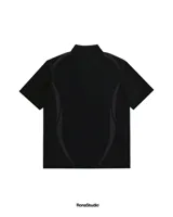 Chomba de manga corta color negro con cuello polo y cierre frontal de tres botones. Presenta un diseño minimalista con detalles tonales en los laterales y el escudo de la Asociación Uruguaya de Fútbol en 3D aplicado en el centro del pecho.
