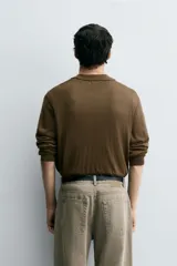 Polo de punto de manga larga con cuello solapa y abertura frontal, confeccionado en tejido de viscosa con acabado en rib.