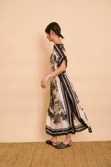 Vestido midi amarillo y blanco con estampado de paisajes y detalles de rayas en el cuello y el dobladillo, de corte holgado, mangas cortas y lazo ajustable en la cintura.