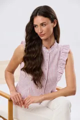 Musculosa de lino rayada con cuello mao y volados en los hombros. Presenta diseño de rayas verticales y aplique de etiqueta con logo en la parte posterior.