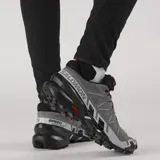 Championes Salomon Speedcross 6 de color negro, diseñados específicamente para trail running. Presentan una estructura robusta y técnica, capellada sintética y textil con refuerzos termosellados, sistema de cordones de ajuste rápido Quicklace y suela con tacos profundos para máxima tracción en terrenos difíciles.