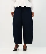 Pantalón de jean azul oscuro con corte barrel, tiro alto y diseño de piernas amplias con terminación afinada. Cuenta con cintura con pasadores, cierre frontal con botón y bolsillos funcionales.