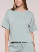 Conjunto de buzo de manga corta con hombros caídos y escote redondo, acompañado de un pantalón tipo wide leg de tiro alto con cintura elástica y cordón de ajuste, en color verde.