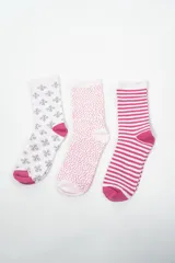 Pack de tres pares de medias de caña media, con diseños estampados. Un par es blanco con estampado de flores grises y puntera fucsia, otro par es blanco con lunares fucsias y puntera rosa, y el tercer par es blanco con rayas horizontales fucsias y puntera fucsia.