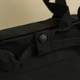 Bolso tipo duffel color negro, plegable, elaborado con ripstop reciclado.