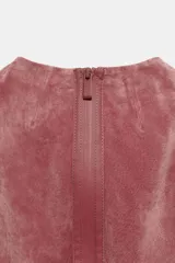 Vestido midi de piel color rosado, con cuello redondo y diseño sin mangas. Presenta costuras marcadas y cierre en la espalda con cremallera oculta.
