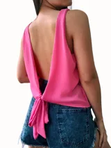 Blusa fucsia sin mangas con escote profundo en la espalda y detalle de nudo en la parte inferior trasera.