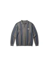 Chomba de manga larga con diseño de rayas verticales en tonos marrón y azul. Presenta cuello polo con cierre de botones y parches decorativos en el pecho.