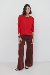 Jean de corte wide leg en color bordó, con costuras a contratono y diseño de cinco bolsillos.