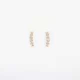 Par de aros dorados con forma de barra levemente curvada, con cristales cúbicos de zirconia incrustados.