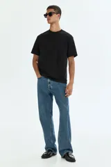 Remera negra de corte relajado, confeccionada con tejido liviano COOLMAX con cuello redondo y mangas cortas.