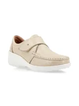 Zapato tipo slip-on color crudo, confeccionado en cuero, con cierre de velcro ajustable en el empeine, costuras visibles y suela de plataforma blanca.