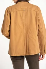 Sobrecamisa de algodón en color camel, con cuello camisero en contraste de tono oscuro, cierre frontal de botones y bolsillos laterales aplicados.