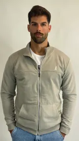 Campera de algodón con cierre frontal completo, cuello alto tipo bomber, puños y ruedo acanalados y bolsillos frontales tipo canguro. Presenta un pequeño logo bordado en el pecho.