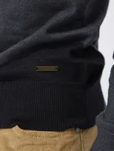 Sweater de punto color negro, con cuello polo y escote en V, de manga larga y diseño ajustado.
