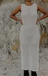 Vestido largo sin mangas de tejido de punto calado color blanco hueso, de corte recto y silueta ajustada.