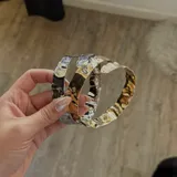 Brazalete plateado con textura irregular.