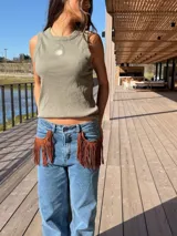 Musculosa gris oscuro de corte recto, con cuello redondo y diseño sin mangas. Presenta un pequeño bordado frontal de sol en tono amarillo y detalle de ribetes.