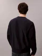 Buzo de felpa azul marino con cuello redondo, manga larga y el logo de Calvin Klein estampado en el pecho. Presenta puños, cuello y dobladillo acanalados.