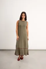 Vestido largo de punto color verde oliva, sin mangas, con cuello redondo y detalles de terminación en tono bordó.