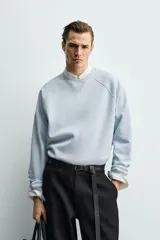 Sudadera de corte regular fit confeccionada en tejido de mezcla de algodón con estructura de piqué y efecto lavado. Presenta cuello redondo, manga larga y acabados en rib en puños y ruedo.