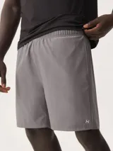 Bermuda deportiva de color gris, con cintura elástica y bolsillos laterales. Presenta un pequeño logo reflectante en la parte inferior de la pierna.