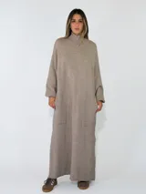 Vestido largo de punto, con cuello alto y mangas largas holgadas. Diseño de corte recto y estilo minimalista.