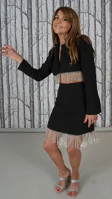 Minifalda negra con flecos plateados en el ruedo.