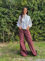 Pantalón wide leg de jean en tono azul, con diseño bicolor que combina paneles laterales en color blanco, bolsillos traseros appliqués y detalles de etiqueta de cuero con la marca.