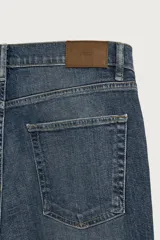 Jeans slim fit de color negro para hombre, con tiro medio, diseño de cinco bolsillos y cierre frontal con cremallera y botón.