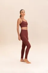 Calza larga color ladrillo, de compresión media y textura acanalada. Presenta un detalle de macramé hecho a mano en los laterales.