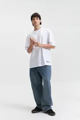 Jean de corte relajado y tiro medio, confeccionado en denim de algodón con un lavado clásico. Presenta un diseño de pierna ancha y recta, con costuras reforzadas en las rodillas y cierre frontal con botón y cremallera.