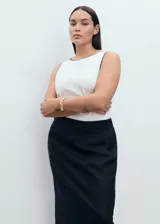 Falda larga de lino color negro, tiro medio, diseño estilo lápiz con abertura en la parte posterior y cierre de cremallera lateral.