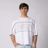 Remera gris oscuro de corte boxy, manga corta amplia, con cuello redondo y diseño gráfico frontal con la palabra "CONCEPTO" delineada en blanco dentro de un panel horizontal.