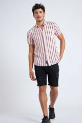 Camisa de manga corta con diseño a rayas verticales en color azul marino y blanco. Presenta cuello clásico, cartera abotonada frontal y logo bordado en el pecho. Posee un corte slim fit.