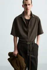 Camisa de corte relajado confeccionada en tejido con mezcla de modal, con cuello solapa, manga corta y cierre frontal de botones.