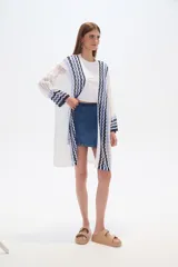 Saco largo de acrílico tejido a crochet, con diseño de rayas horizontales en tonos blanco, azul y negro.