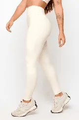 Calza larga color crema de tiro alto, confeccionada en tejido suave y elástico.
