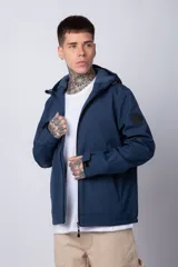 Campera de abrigo color azul, con cierre frontal, capucha ajustable y bolsillos laterales con cierre. Presenta un diseño minimalista con detalle de logo circular en la manga.