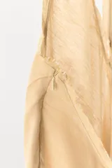 Vestido mini de mezcla de lino en color beige, con cuello halter, escote en V y diseño drapeado fluido.