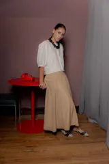Falda larga de corte evasé en color beige, con cintura elástica y bolsillos laterales ocultos.