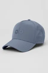 Gorra tipo trucker de alto rendimiento con corona estructurada, paneles traseros perforados para mayor ventilación y cierre ajustable con velcro. Presenta el logo de la marca bordado en el frente.