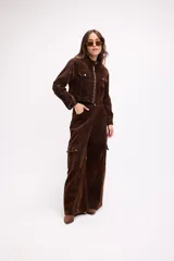 Chaqueta corta de terciopelo negro con efecto desgastado en tono azulado, cuello mao, cierre frontal metálico y bolsillos frontales con tapa y botón.