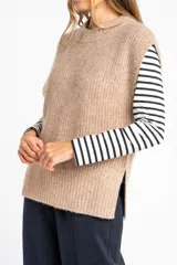 Chaleco de punto color beige con cuello alto y sisas amplias.